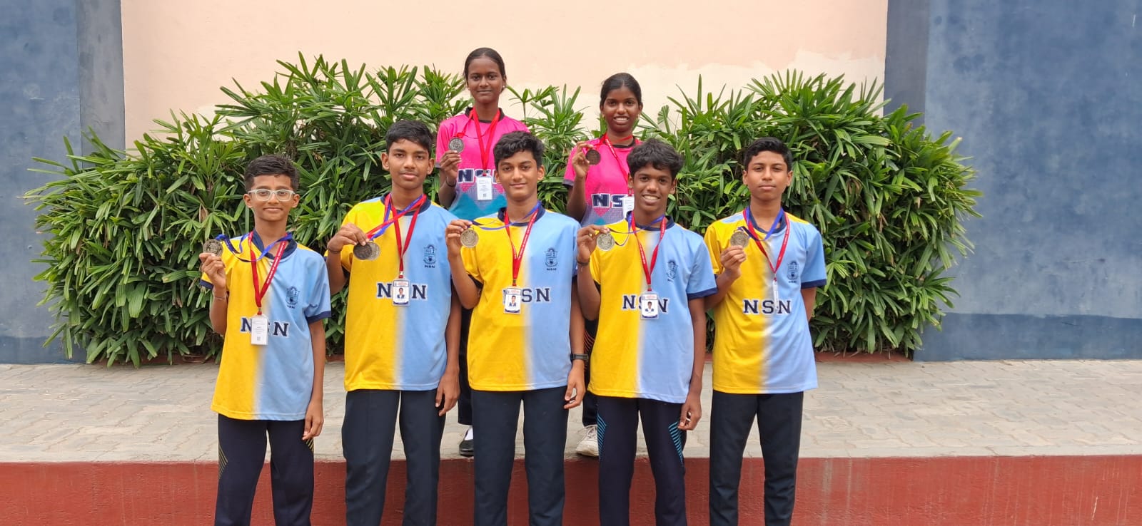 Proud students displaying sports medals and trophies